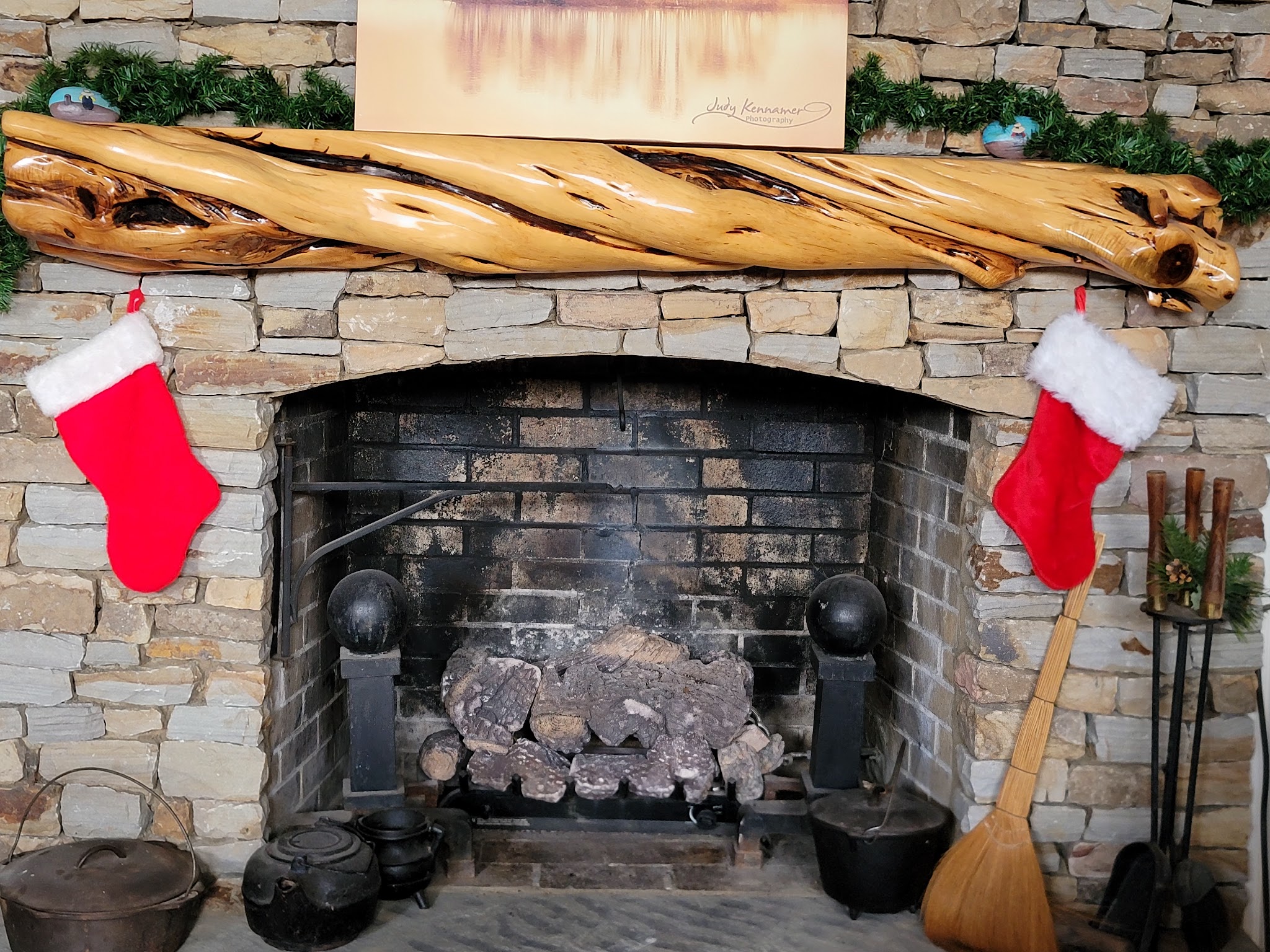 Stone fireplace decorated with Christmas stockings and garland at Guntersville Getaway
