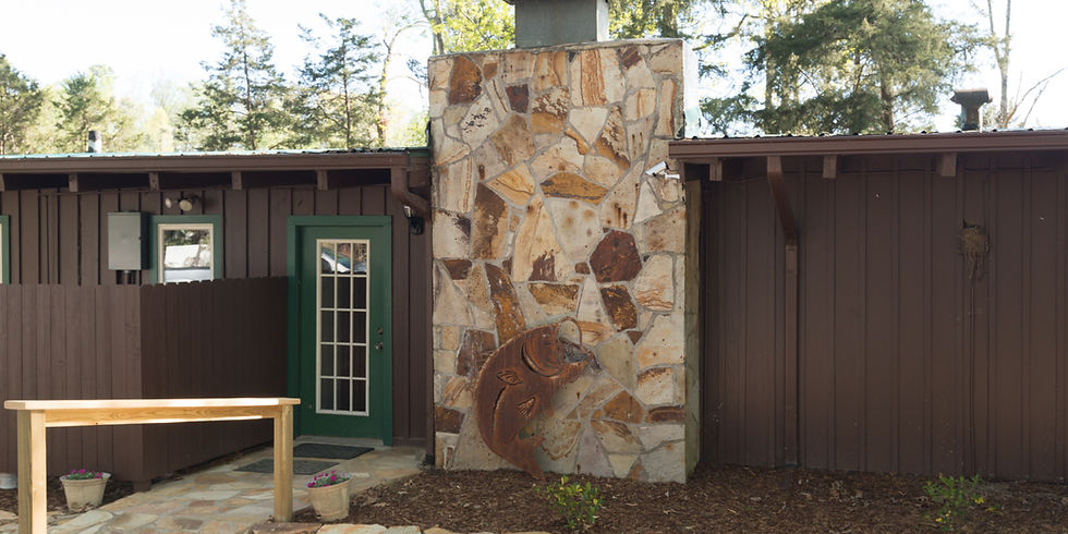 Front exterior of Guntersville Getaway showing stone chimney and covered entry on Lake Guntersville