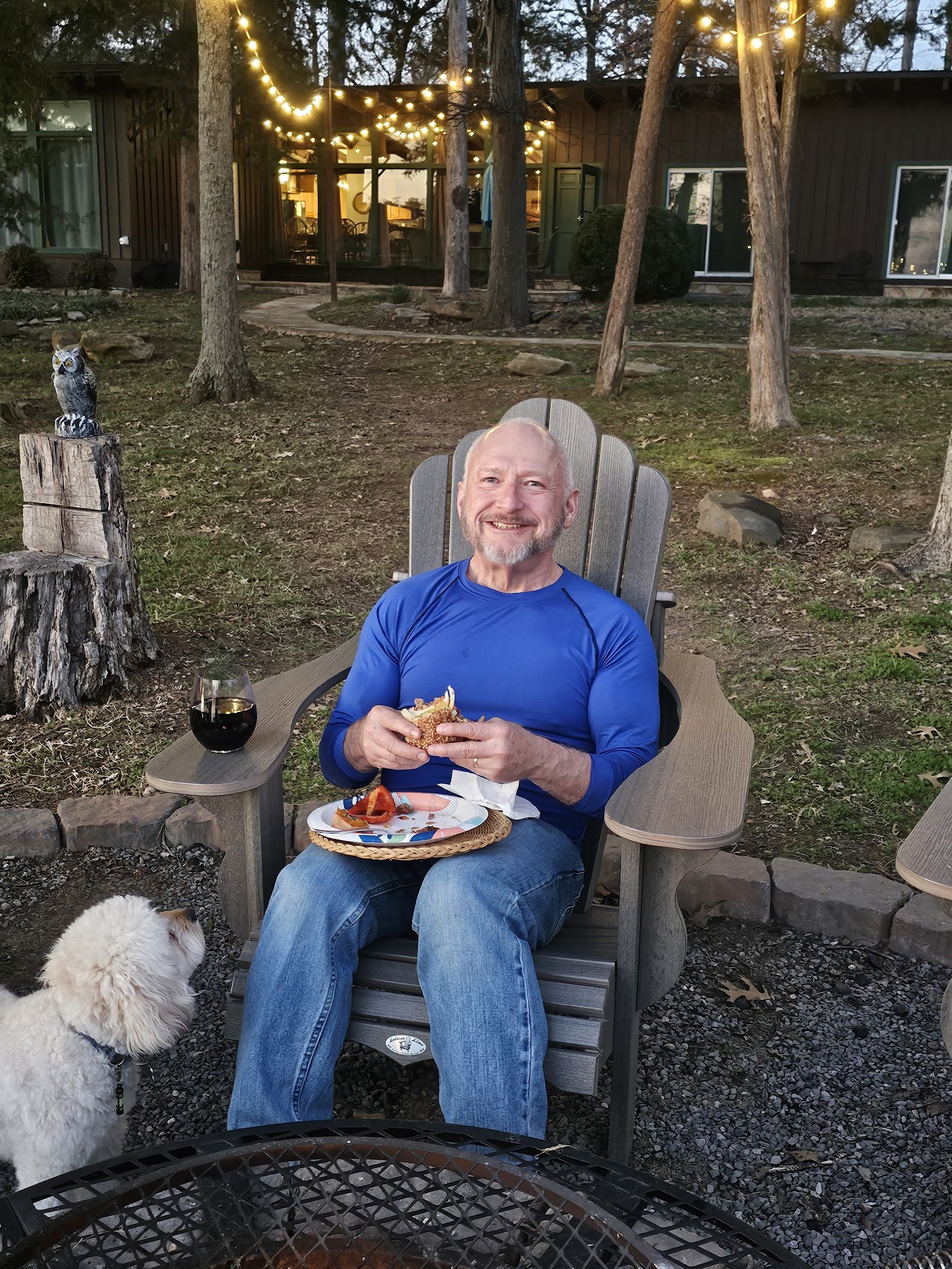 Guest dining with dog in the lakefront yard at Guntersville Getaway